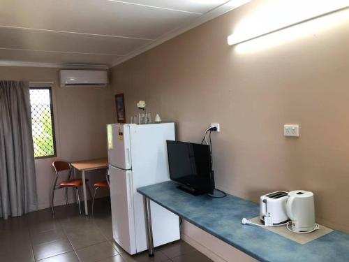 a kitchen with a refrigerator and a microwave at Childers Budget Accommodation in Childers