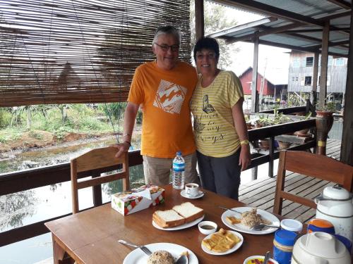 two people standing next to a table with food on it at Innthar Lodge Home Stay in Ywama