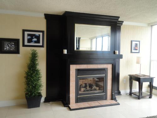 a living room with a fireplace and a mirror at Oceanfront Suites at Cowichan Bay in Cowichan Bay