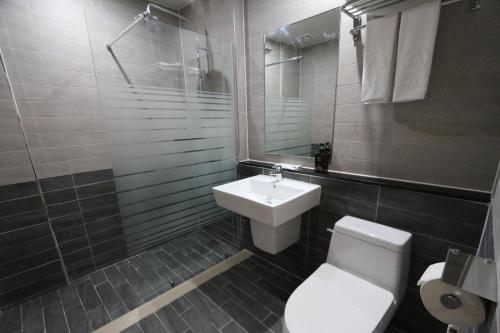 y baño con aseo, lavabo y ducha. en Daedunsan Hotel en Wanju