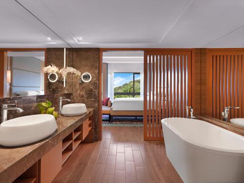 a bathroom with two sinks and a bath tub at Hyatt Regency Kuantan Resort in Kuantan