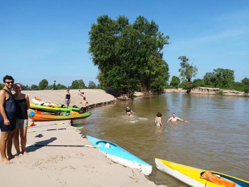 a group of people in the water at a beach at Silver Dolphin Guesthouse & Restaurant in Kratie