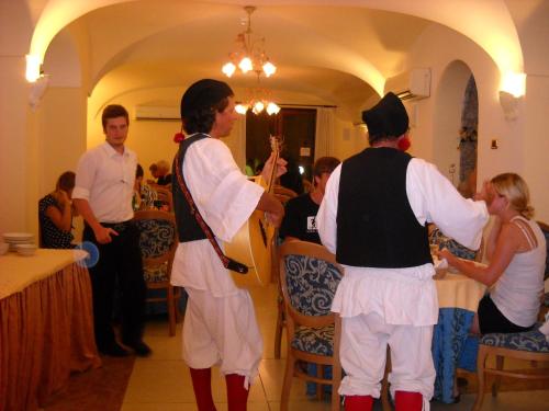 a group of people dressed in white standing in a restaurant at Hotel Villa Franca in Ischia
