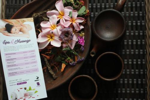 a table with a plate of flowers and a birth certificate at Novena Hotel Bandung in Bandung