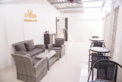 a living room with wicker chairs and a table at ninaguesthouse in Bangkok