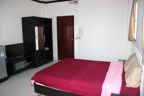 a bedroom with a red bed and a tv at Matini Amata in Ban Hua Phai