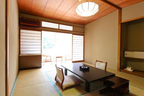 a dining room with a table and chairs at Shima Grand Hotel in Nakanojo