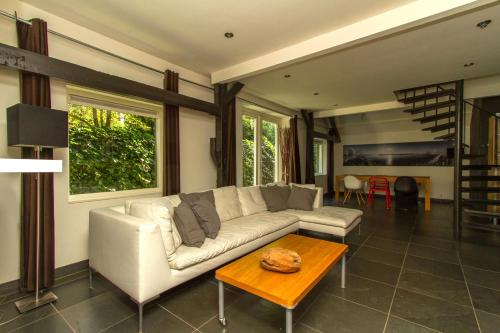a living room with a white couch and a table at Hannahhoeve Private House with wifi and free parking for 1 car in Weesp