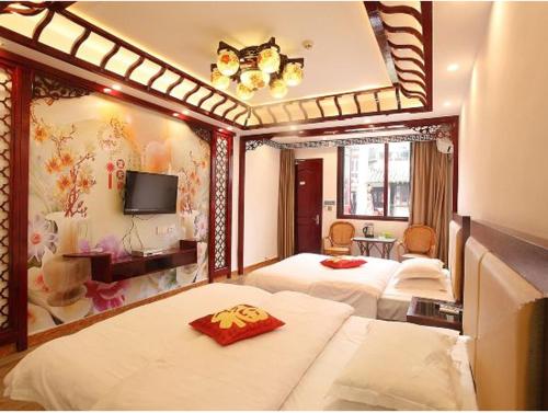 a hotel room with two beds and a tv at Xitang River Time Inn in Jiashan