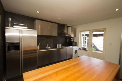 a kitchen with a stainless steel refrigerator and a wooden floor at Hannahhoeve Private House with wifi and free parking for 1 car in Weesp