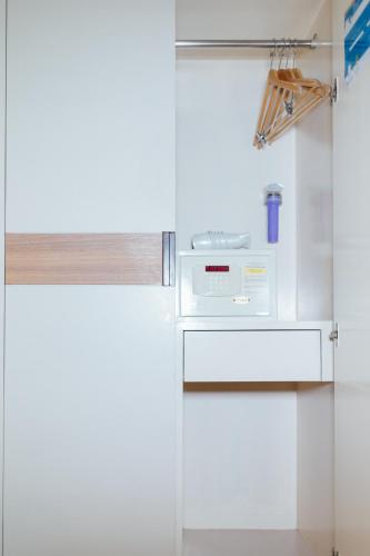 a white refrigerator with a microwave in a kitchen at Seasons Siam Hotel in Bangkok
