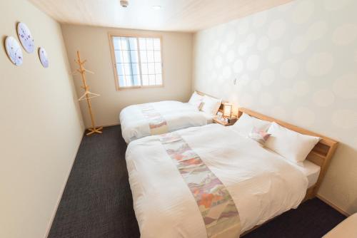 a room with two beds and a window at Stay SAKURA Kyoto Station South I in Kyoto