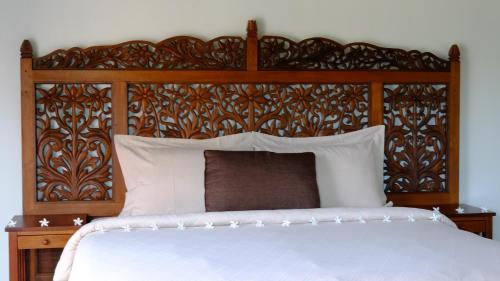 
a bed with a white comforter and pillows at Villa Cathaya - Private Pool in Pantai Cenang
