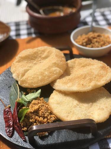 a plate of food with two pita bread on it at Raindrops Resorts Wayanad in Sultan Bathery
