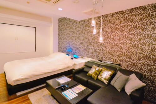 a living room with a couch and a bed at Hotel Aqua Vitae (Adult Only) in Nasu