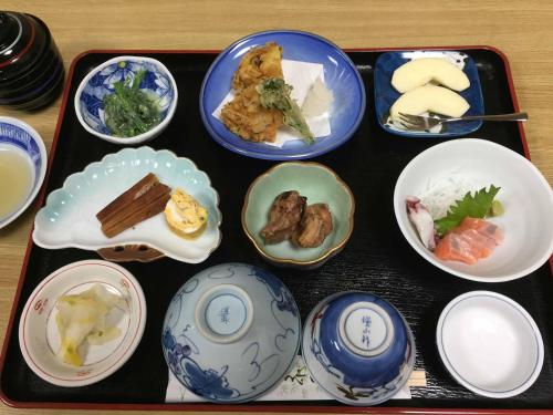 a tray filled with plates and bowls of food at Kimatsu Ryokan in Hiroshima