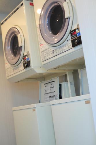 two washers and dryers on shelves in a kitchen at K's Street Hotel Miyazaki in Miyazaki