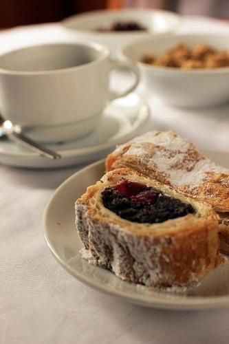 a white plate with a piece of bread with berries on it at Hotel Zlatá Váha in Prague