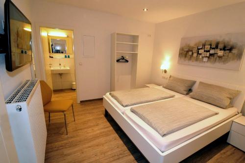 Schlafzimmer mit einem großen weißen Bett und einem Schreibtisch in der Unterkunft Ferienwohnungen Schmider in Rust