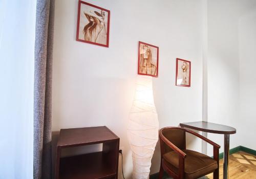 a room with a chair a table and pictures on the wall at Coffee Home Hostel in Lviv