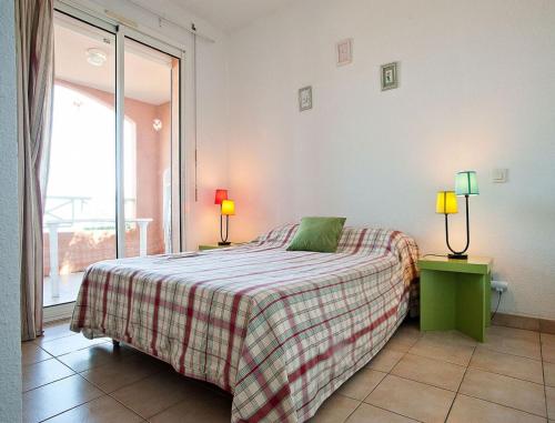 1 dormitorio con 1 cama, 2 lámparas y ventana en Résidence Suarella, en Saint-Florent