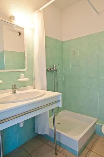 une salle de bain avec un lavabo, un miroir et une baignoire dans l'établissement Résidence Suarella, à Saint-Florent