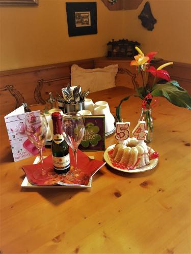 a table with a bottle of wine and glasses on it at Maier Pension in Bayerisch Eisenstein