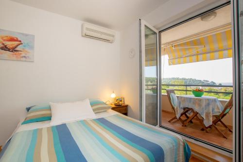 1 dormitorio con cama, mesa y balcón en Apartment IRENA with Bikes included, en Pula