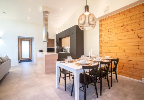 a kitchen and dining room with a white table and chairs at Riverside luxury suites in Rovaniemi