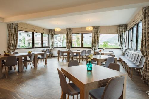 a restaurant with tables and chairs and windows at Hotel DADA Termal in Călimăneşti