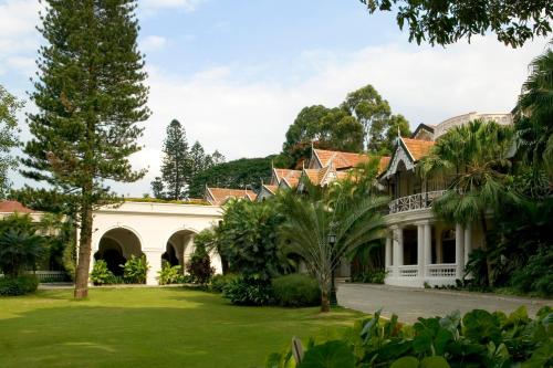 uma vista exterior de uma casa com um pátio verde em Taj West End em Bangalore