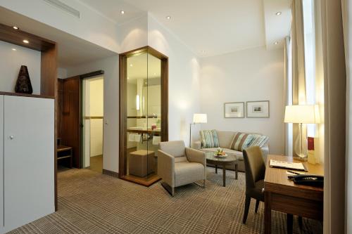 a living room with a couch and a table at Kastens Hotel Luisenhof in Hannover