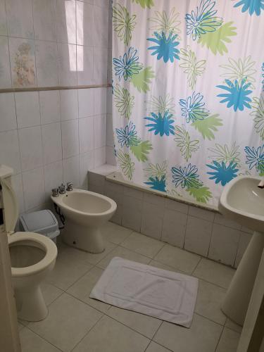 a bathroom with a toilet and a shower curtain at Holiday Suites Hotel & Beach Resort in Jounieh