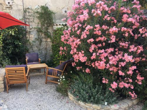 サリアンにあるLa Villa d'Arthureのテーブルと椅子の横に咲くピンクの花