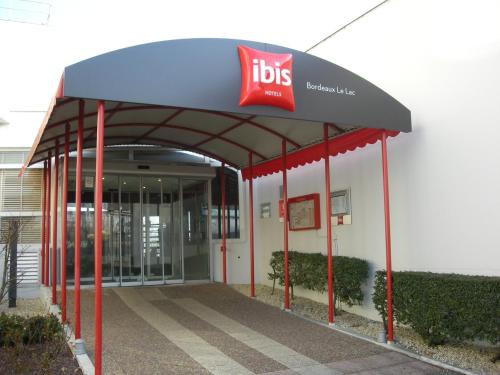 a building with a bus stop with a ups sign on it at ibis Bordeaux Lac in Bordeaux