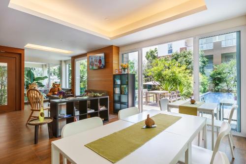 a living room with white tables and chairs and windows at U Tiny Boutique Hotel Suvarnabhumi Bangkok - SHA Plus in Lat Krabang