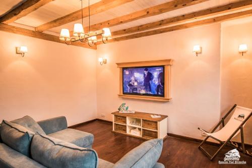 a living room with two couches and a tv at Ranczo Pod Strzechą in Stara Kamienica