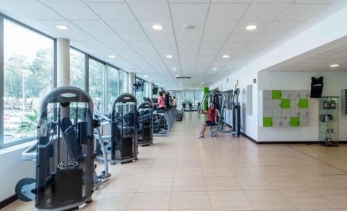 a gym with many treadmills and people in it at Suittes Hotel in Algeciras