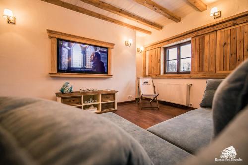 a living room with a couch and a tv at Ranczo Pod Strzechą in Stara Kamienica