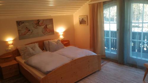 a bedroom with a bed with white sheets and a window at Rosis Cottage in Lienz
