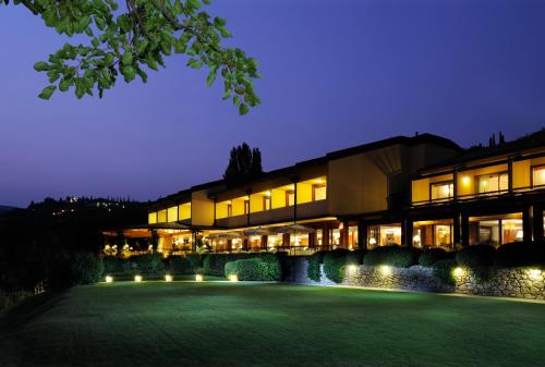 a building with a lawn in front of it at night at Poiano Garda Resort Hotel in Garda