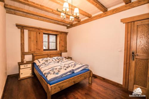a bedroom with a bed and a window at Ranczo Pod Strzechą in Stara Kamienica
