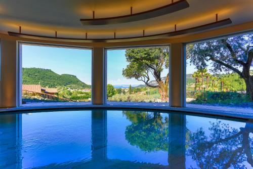 a swimming pool in a house with a view of the water at Poiano Garda Resort Hotel in Garda