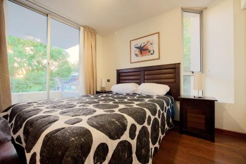 1 dormitorio con cama grande y ventana grande en Bellavista Blanc, en Santiago