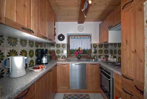 a kitchen with wooden cabinets and a stainless steel appliance at Ferienhäuser Reither Almen in Reith im Alpbachtal
