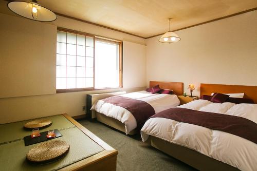 a hotel room with two beds and a window at Senami View Hotel in Senami