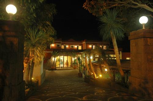 a house at night with palm trees and lights at Hotel Villa Franca in Ischia