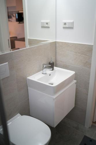 a bathroom with a white sink and a toilet at Ferienwohnung Pfingsberg EG in Ratingen