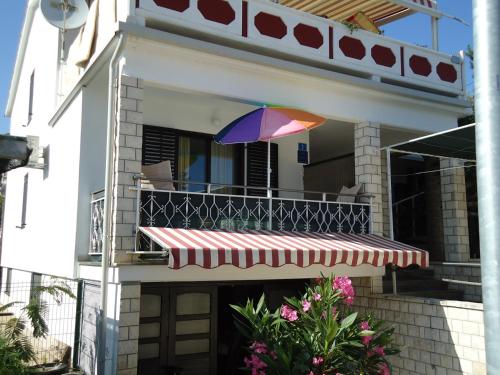 a colorful umbrella sitting on the balcony of a house at Studio Apartment Carli in Savudrija