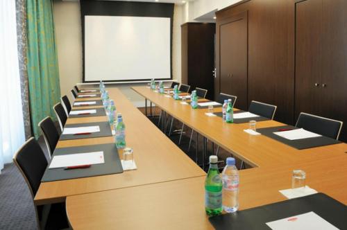 a conference room with long tables and chairs and a whiteboard at Residhome Nantes Berges De La Loire in Nantes